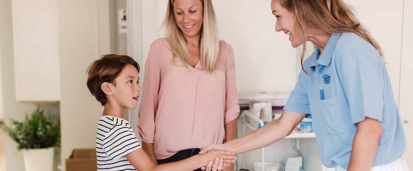 Doktor, patient, barn med mamma.